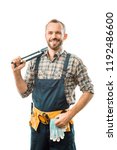 Small photo of smiling plumber with tool belt holding monkey wrench and looking at camera isolated on white