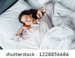 attractive young woman in pajamas waking up in bed in the morning
