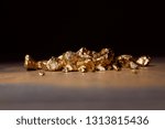 Small photo of unwrought golden stones on marble table isolated on black