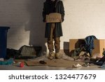 Small photo of cropped view of houseless man holding piece of cardboard with "homeless" handwritten text