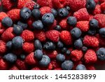 close up view of fresh ripe mixed raspberries and blueberries 