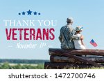 back view of patriotic child holding american flag near veteran father while sitting in fence with thank you veterans illustration