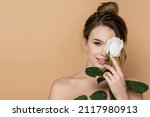 happy young woman holding white rose near face isolated on beige