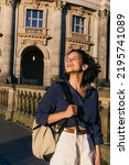Small photo of sunshine on face of pleased young woman with backpack near bode museum in berlin