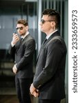 Small photo of bodyguard service, private security, professionals in suit and sunglasses standing in hotel lobby, handsome man with earpiece, communication, luxury hotel, vigilance, protection and work