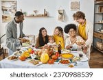 Small photo of Thanksgiving traditions, multicultural friends and family gathering at festive table with turkey