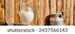 Small photo of object photo of churn and jar of fresh milk placed outside of village house on modern farm, banner