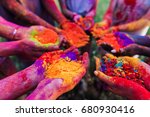 close-up partial view of young people holding colorful powder in hands at holi festival 