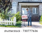 young man with sale board selling his house