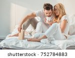 young beautiful couple drinking coffee in bed at morning