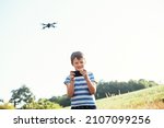 child watches the video on the smartphone from the drone's camera. dark gray drone quadcopter with digital camera and sensors flying. Soft focus