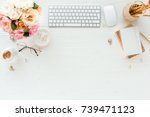Female workspace with computer, pink and beige roses flowers bouquet, accessories, diary, glasses on white wooden background.  Flat lay home office desk. Top view feminine background.