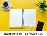 Small photo of Notebook mockup on yellow office desk. Top view. Isolated blank sheet for design, list, script, text, draw, annotations and creativity. Pencil, cup of coffee cell phone, headphones and plant beside.