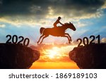 Small photo of The rider on the horse jump from 2020 to 2021 at sunset. Happy New Year concept.