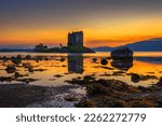 Sunset over Castle Stalker in Scotland, United Kingdom. Castle Stalker is a picturesque tower house located on a small island in Loch Laich, in the west coast of Scotland.