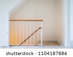 Inside house home interior, townhouse with stairs, steps or staircase leading down to basement level with yellow light lamp glowing, railing