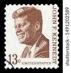 Small photo of UNITED STATES OF AMERICA - CIRCA 1967: A used postage stamp printed in United States shows a portrait of the President John Fitzgerald Kennedy in brown, circa 1967. ( Isolated on black background )