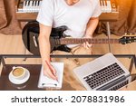 Small photo of male composer, songwriter enjoy writing hit song while playing black electric guitar in home studio. songwriting concept