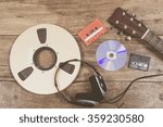 Small photo of studio reel, headphone, CD, cassette, Digital Audio Tape & guitar on wooden table recording media evolution technology concept