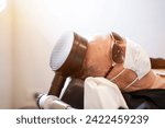 Small photo of Electrical muscle stimulation (EMS) on elderly patient's head. EMS is the elicitation of muscle contraction using electric impulses .