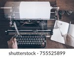 Small photo of top view of man using vintage manual typewriter on rustic wooden table with motion blur due to carriage return