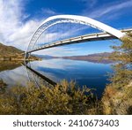 Small photo of Roosevelt Bridge Arch Ellipse Reflected in Apache Trail Lake Calm Water. Scenic Superstition Mountains Landscape Angle View, Arizona Southwest US