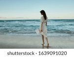 young woman in a white summer dress on the sea