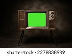 Small photo of Retro old television with chroma key green screen standing in a dark room, antique and vintage TV style photo.