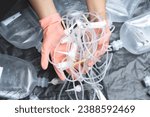 Small photo of Hands of female officers sorting toxic waste, IV tubes, extension tubes, Intravenous therapy acetate ringer's injections, saline bottles, and Syringes, from clinics or hospitals for recycling