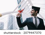 Handsome businessman wear graduation degree hat and stand on stair near cityscape, business education concept