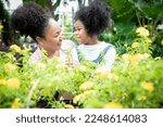Mother and daughter choosing plants or herbs at garden center shop. Botanical garden, flower farming, horticultural industry concept