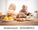 Small photo of Asian muslim women select and eat chicken biryani , inthaphalam or dates, southern flat bread arranged traditionaly in an earthen ware lined with many menu. Break the fast