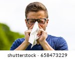 Small photo of a young man snorts in a handkerchief