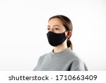 Portrait of young woman wearing black face mask isolated on gray background. Dust protection against virus. Coronavirus pandemic time. Female looking at camera