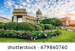 Kazan Cathedral in St. Petersburg under a blue sky with clouds and beautiful red and white peonies in front of him