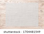 Top view of empty white tablecloth on wooden background with copy space.