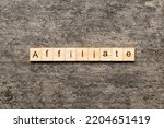 Small photo of AFFILIATE word written on wood block. AFFILIATE text on cement table for your desing, concept.