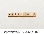 Small photo of AFFILIATE word written on wood block. AFFILIATE text on cement table for your desing, concept.
