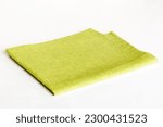 top view with green kitchen napkin isolated on table background. Folded cloth for mockup with copy space, Flat lay. Minimal style.