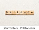 Small photo of Sentence word written on wood block. Sentence text on table, concept.