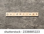 Small photo of Guidelines word written on wood block. Guidelines text on table, concept.