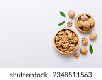 Small photo of Walnut kernel halves, in a wooden bowl. Close-up, from above on colored background. Healthy eating Walnut concept. Super foods with copy space.