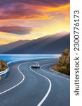 Small photo of Car in motion in the highway landscape under the coastal road. Road landscape at colorful sunset. Car driving on the highway. Nature scenery on sea beach. Travel journey for summer trip on road.