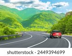 Road landscape with red car in...