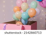 closeup of a huge pink box with colorful balloons inside. birthday present, surprise. holiday goods. High quality photo
