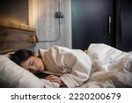 Young Asian woman sleeping peacefully in bed at night at resort hotel Young Asian girl sleeping cozily on bed at bedroom She get deep sleep on bed 