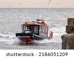 Small photo of LOWESTOFT, SUFFOLK, UK â€“ JULY 30, 2022: CRC LODESTAR, an 11 metre cabin RIB safety boat enters Lowestoft's outer harbour during the International Smack Race Festival.