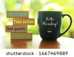 Small photo of Hello Monday. Inspirational quote - Dream big. Set goals. Take action. Succeed. With colorful positive motivational words on wooden blocks and morning cup of coffee closeup.