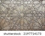Small photo of Detail of metal door with traditional islamic ornament. Copper window shutter with antique and national moroccan floral pattern. Oriental ornaments with artistic with chasing for brass