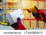 Small photo of Reading a barcode from a cardboard box. Hands in work gloves hold a barcode reader and a box. Acceptance of goods to the warehouse. Product encoding.